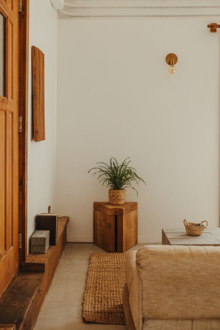 A cozy living area featuring a vintage Roche Bobois sectional sofa and a hand-carved cedar stool.
