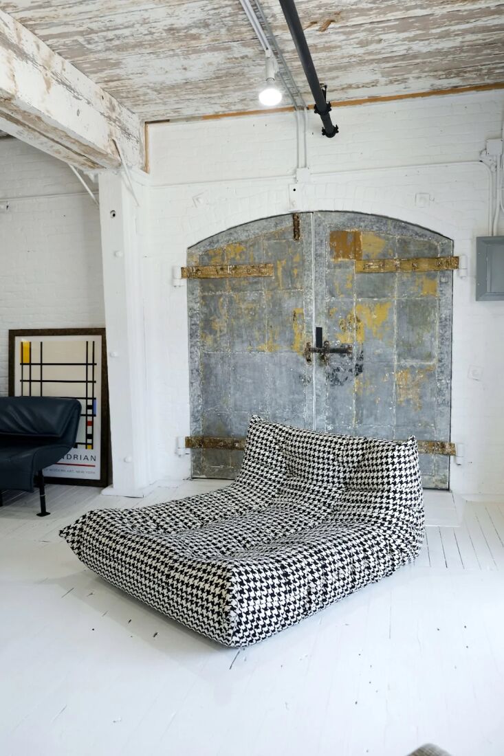 A houndstooth pattern Togo chaise lounge showing its quilted, folded form.