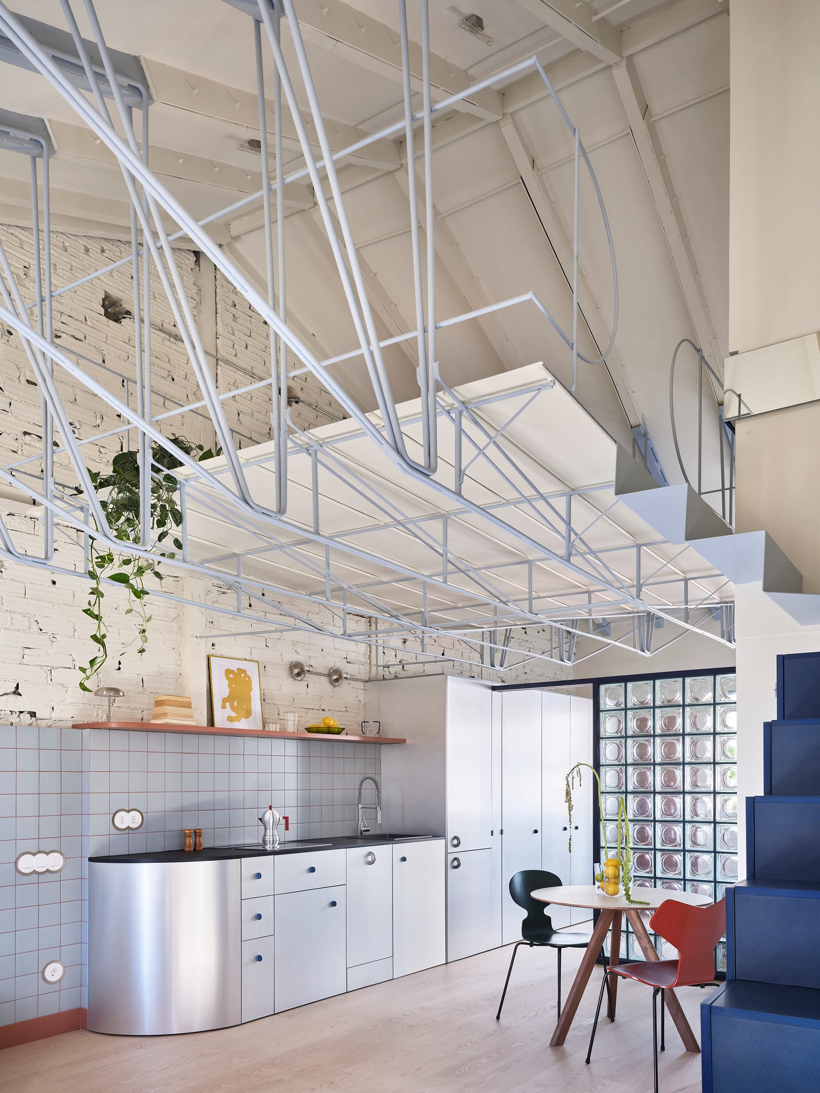 Dining area with a HAY table and Fritz Hansen chairs under the mezzanine.