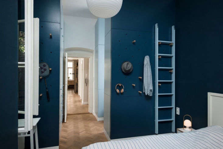 A wall featuring a system of adjustable wooden pegs for flexible gear and accessory storage.