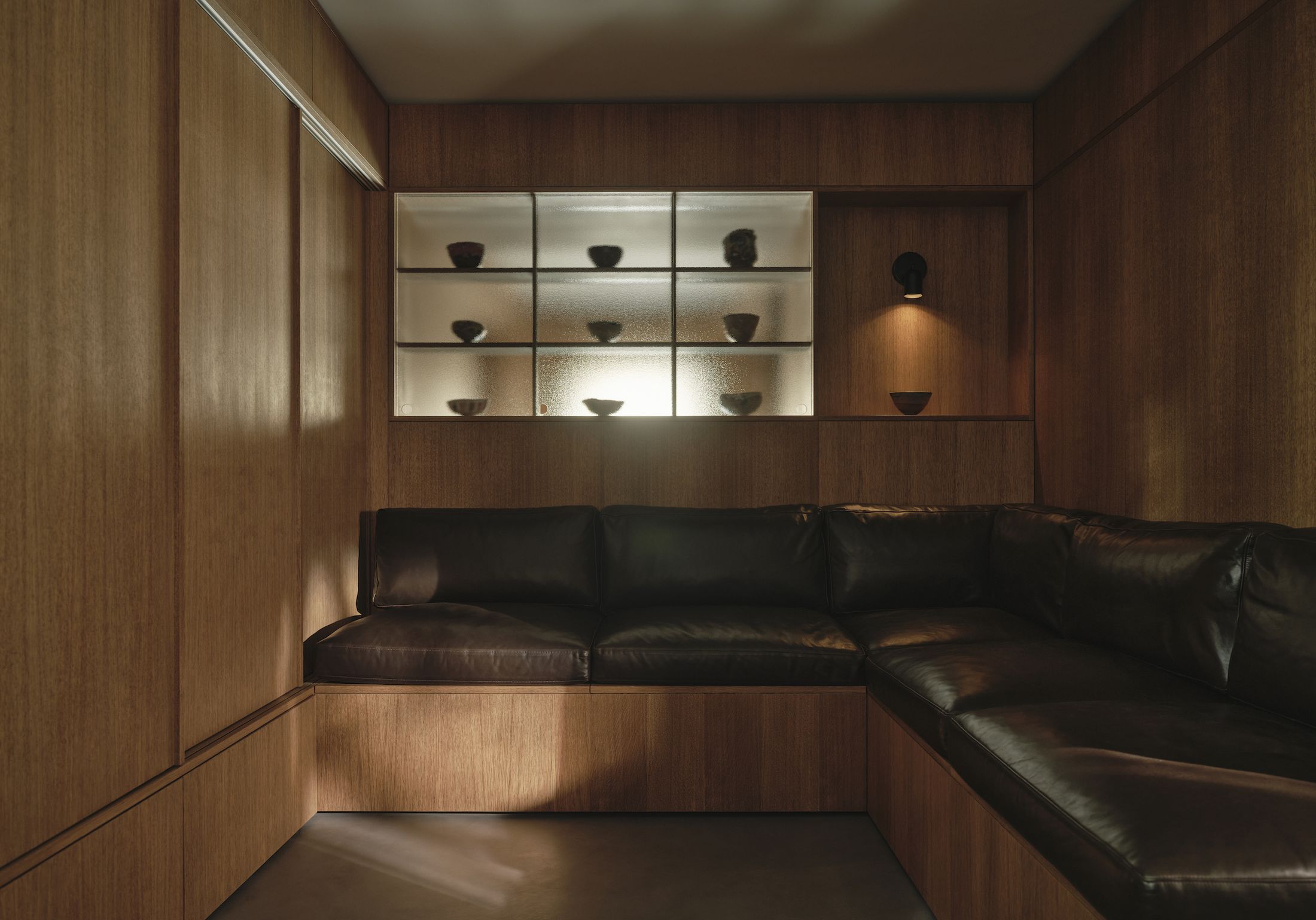 A sunken dining area in a modern Japanese interior, integrated with microcement floors and oak joinery.