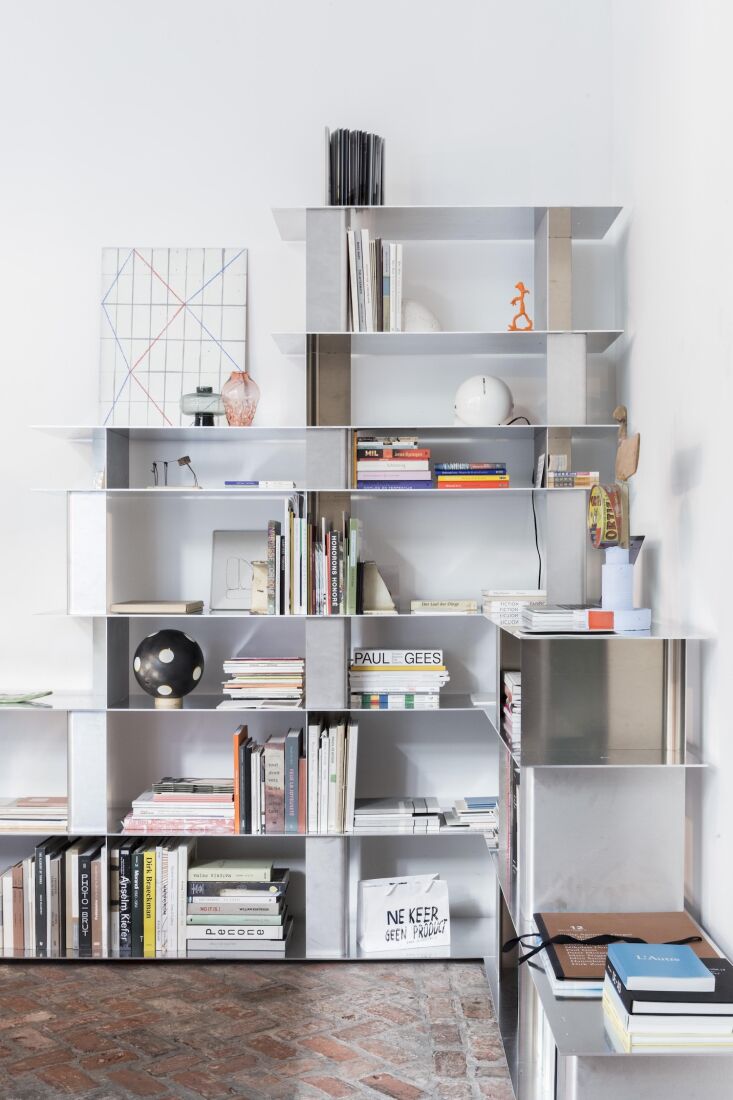 A medium-sized multi-tiered aluminum shelf in a minimalist interior.