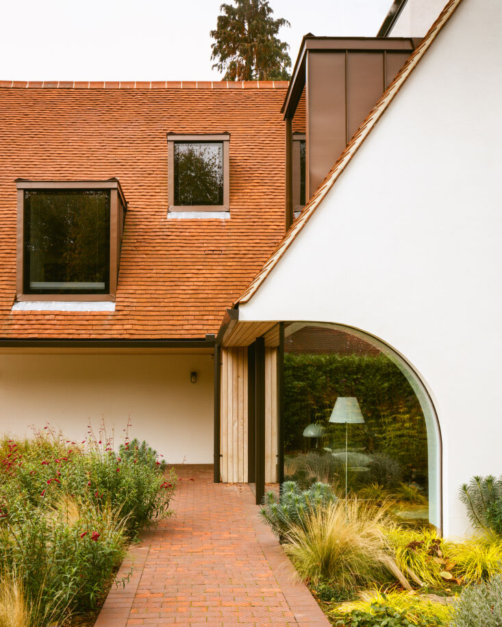 Entrance path featuring Sweet Chestnut wood cladding and red clay Keymer roof tiles.