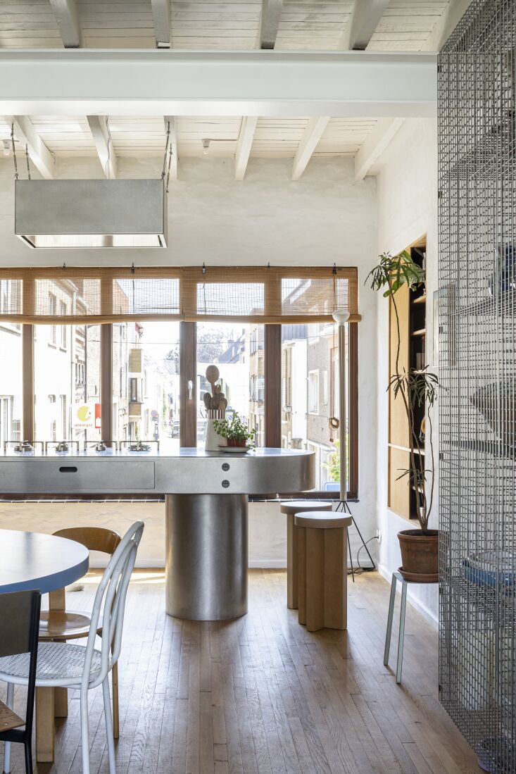 A modern stainless steel kitchen island with sleek cabinets inspired by 1960s industrial design.