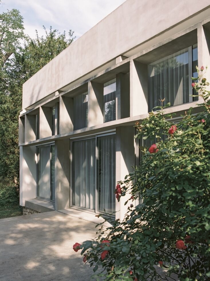 A Brutalist concrete patio extending into a green yard.