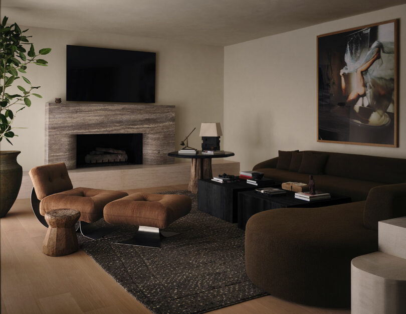 Modern living room featuring a massive stone fireplace, neutral-toned sectional sofa, and abstract art.