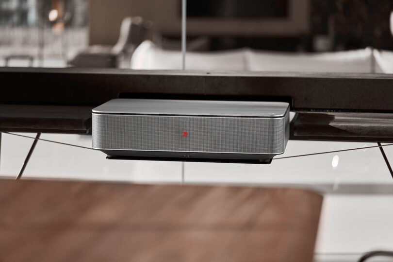 Close-up of a silver Leica projector unit on a sleek surface.