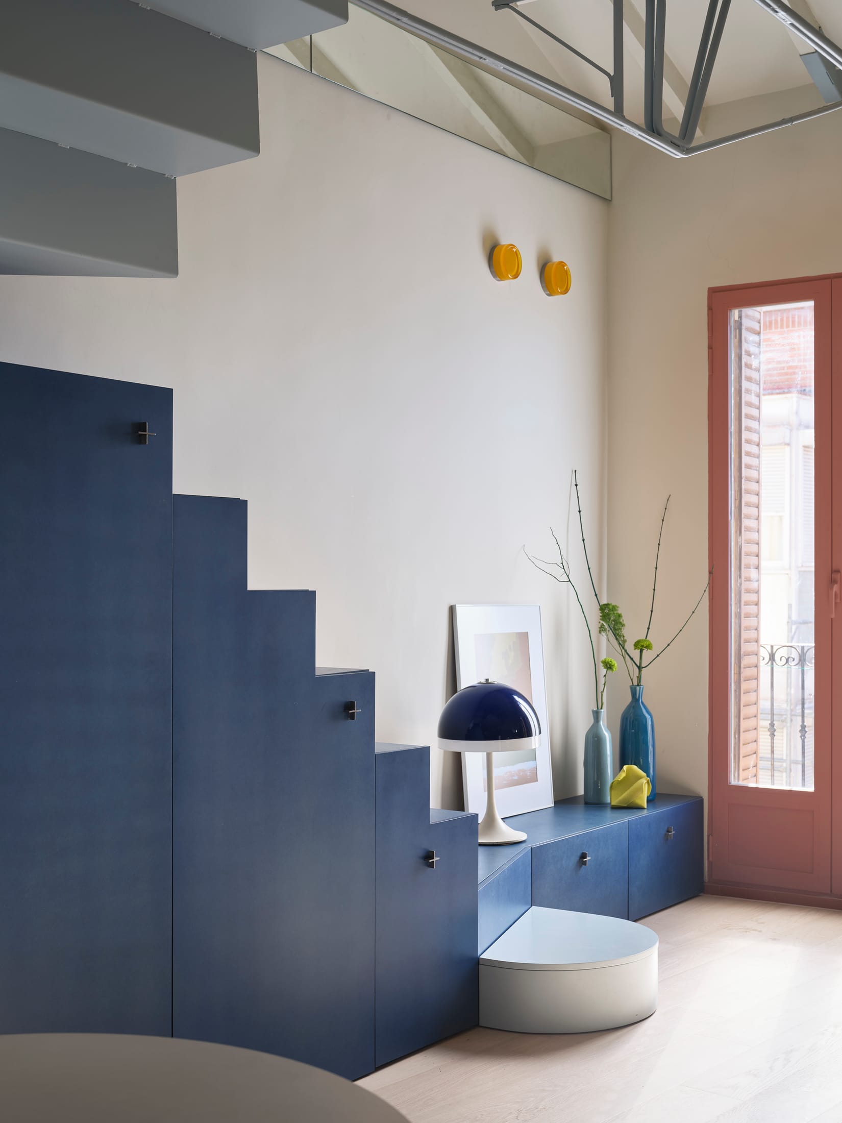 View from the ground floor showing the dark floor tones transitioning to the bright blue upper level.
