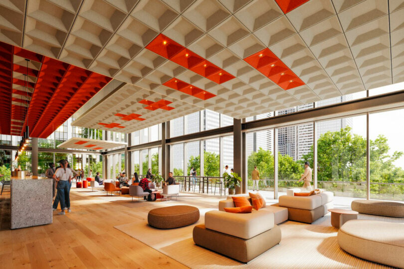 Modern open lobby featuring bright orange acoustic ceiling accents and large windows.