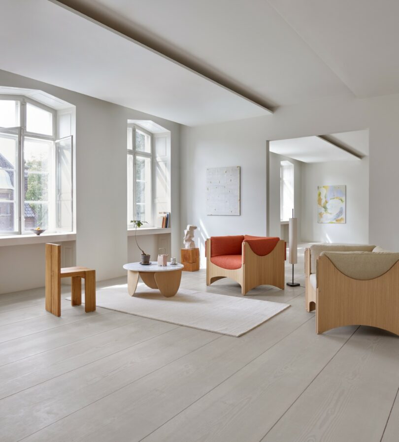 A sun-drenched minimalist living room featuring sustainable wood furniture and neutral tones.
