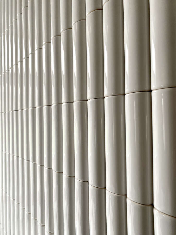 Vertical curved ceramic tiles in a matte-glazed finish on a kitchen backsplash.