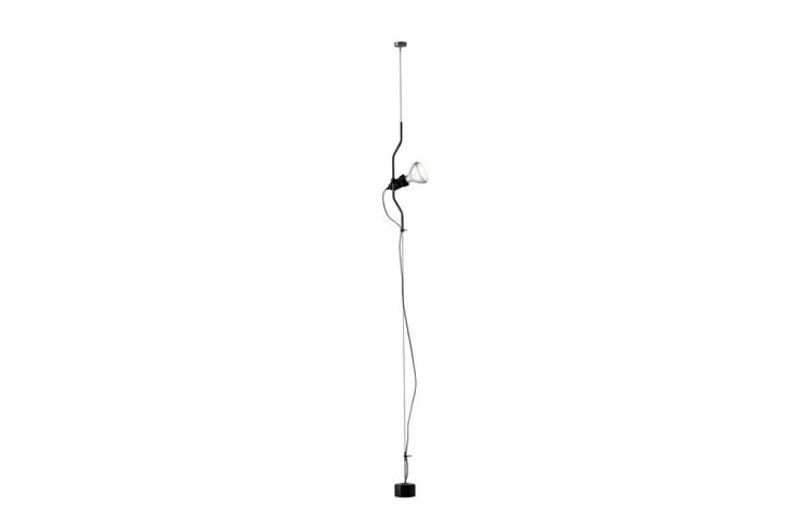 A Parentesi suspension lamp by Flos hanging in the corner of a minimalist room.