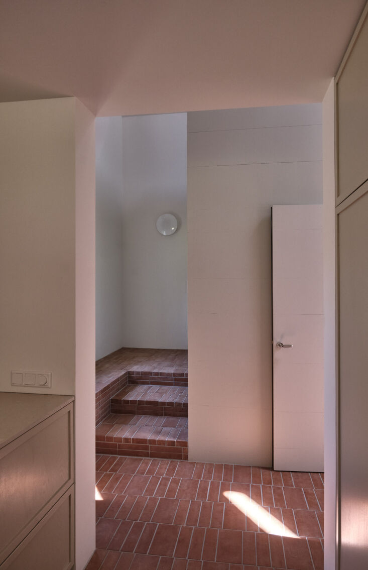 A laundry area and storage space tucked neatly under a wooden staircase.