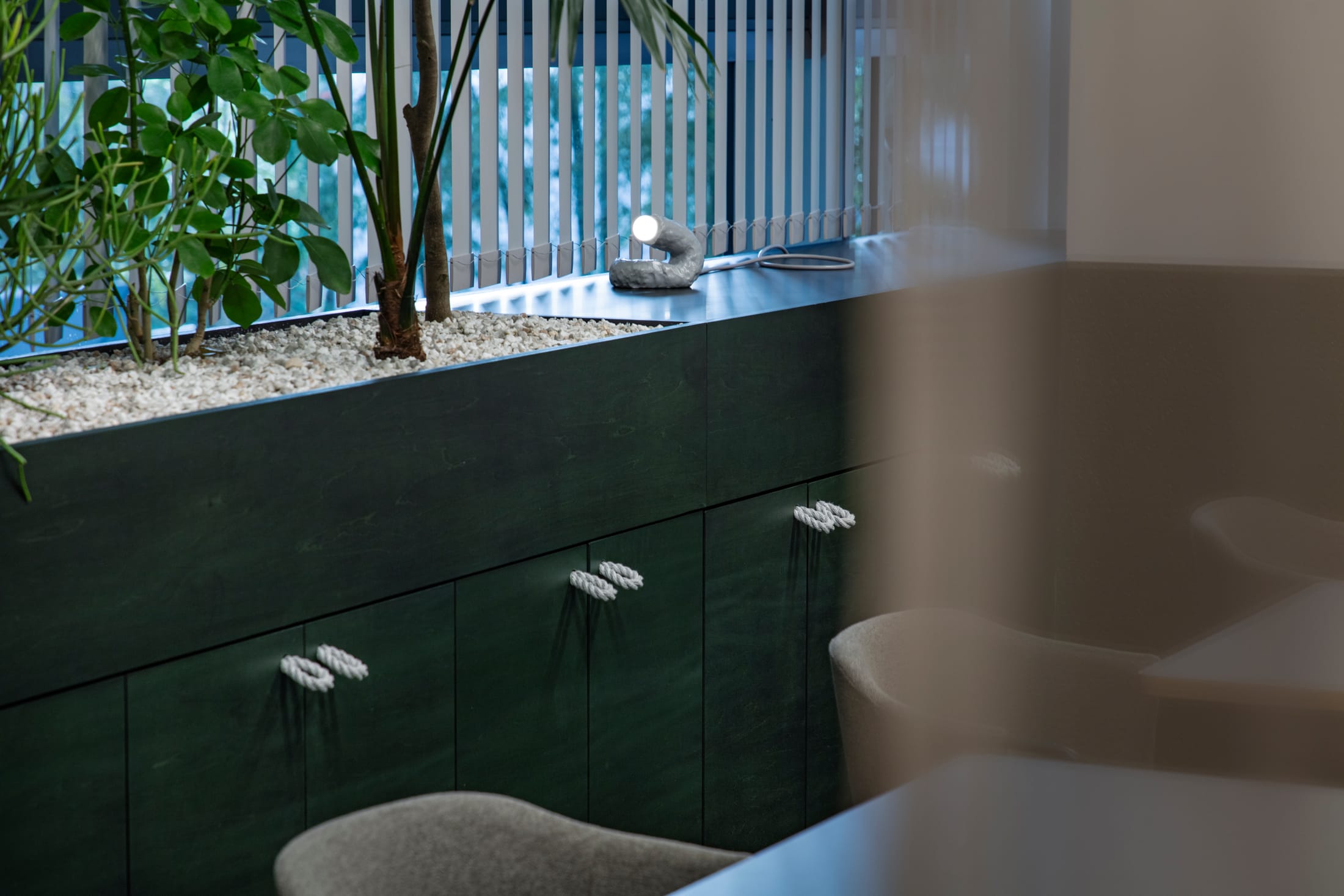 A workspace with tiered wooden platforms, green plants, and various seating heights.