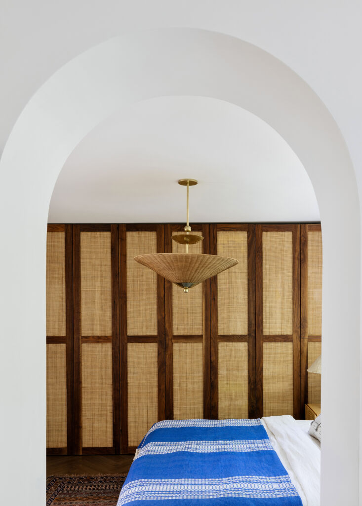 Perilla Pendant by Dabito for Mitzi featuring a wicker rattan shade and brass spheres.