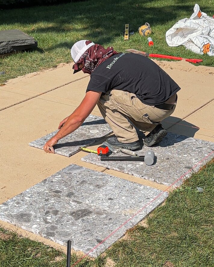 A close-up of layered garden planting featuring various shades of green and different foliage heights.