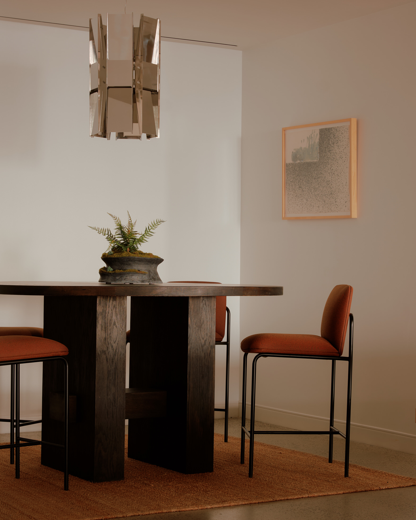 Close-up of sculptural mid-century inspired chairs and a low table in a lounge area.