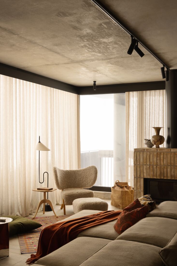 Living room featuring a modular grey Extrasoft sofa and a white sheepskin TMBO chair.