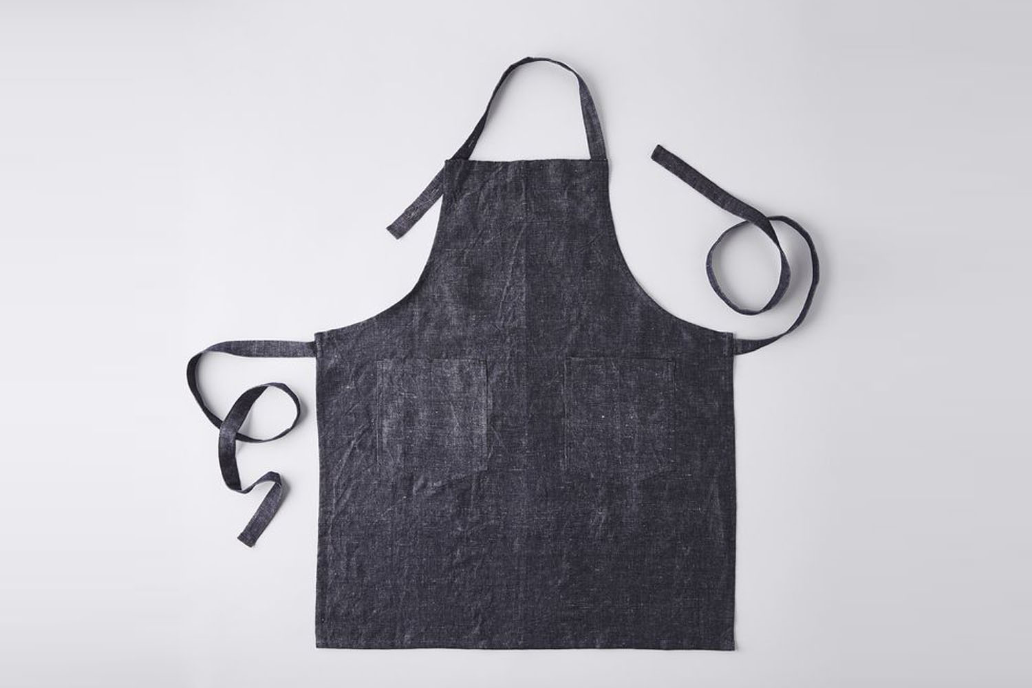 Close up of a blue linen-cotton blend apron showing the fabric grain.