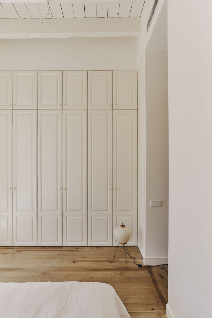 A master bedroom with built-in closets and a Noguchi Akari lamp providing soft ambient light.