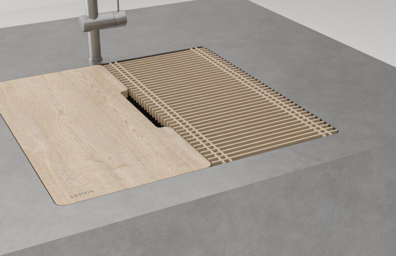 A kitchen sink with a wooden slatted dish rack and cover integrated into the countertop.