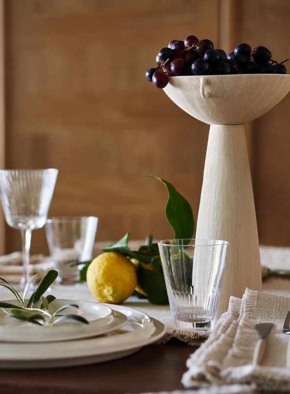 The Es Taller dining table set in a sunlit room with minimal decor.