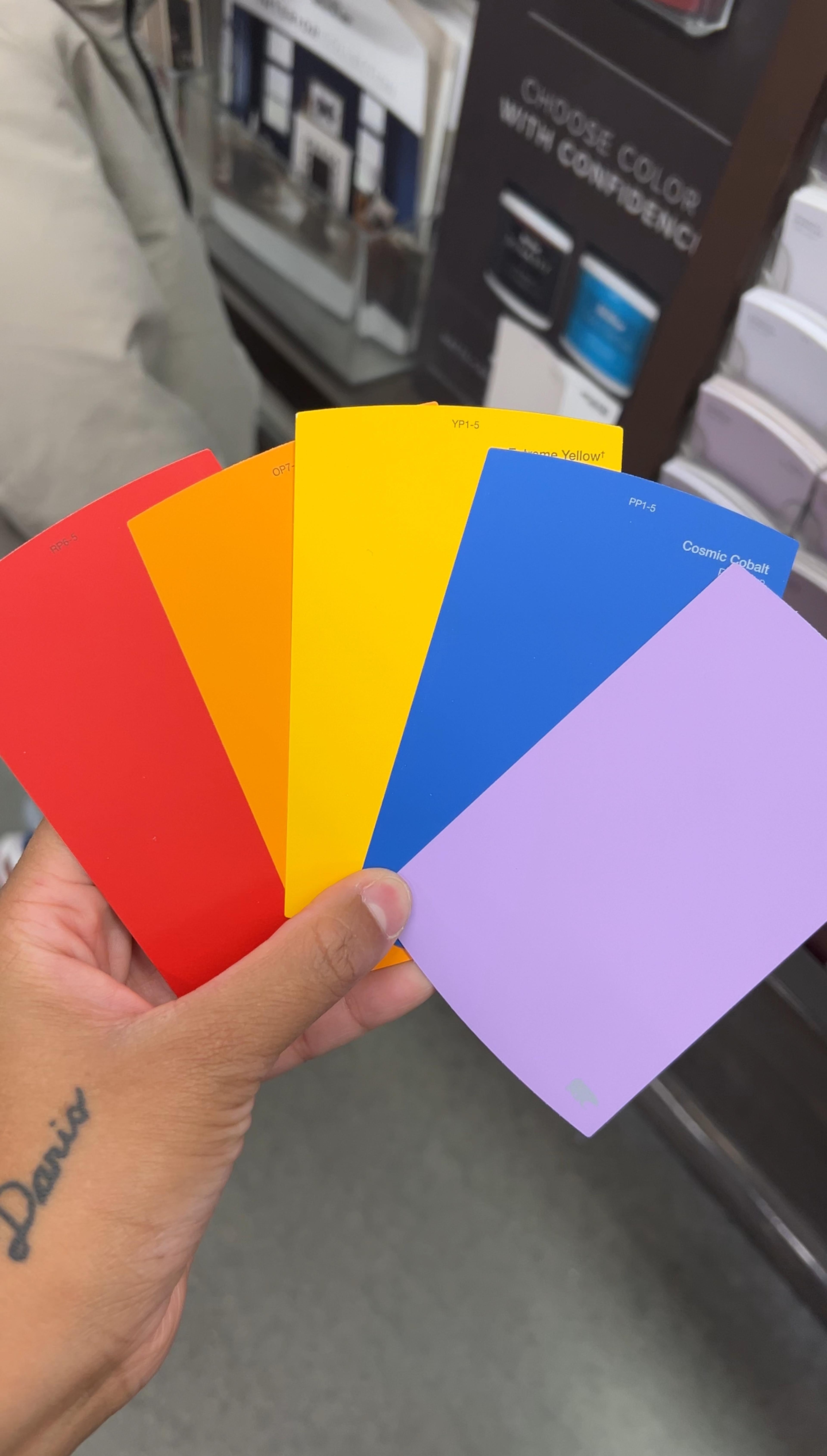 A collection of various paint color chips in modern earthy and jewel tones.