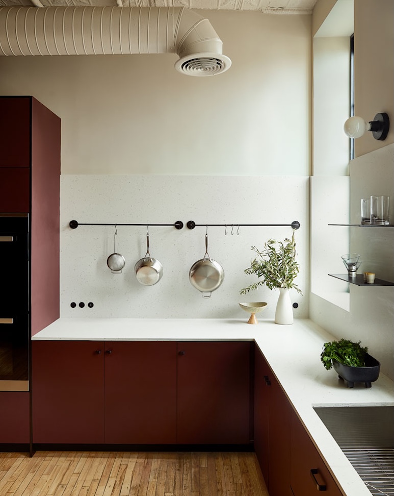 Modern kitchen cabinets with a burgundy matte linoleum finish and a speckled stone countertop.
