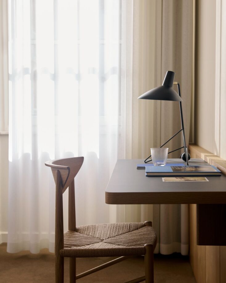 A linoleum-topped Pavilion Desk by Anderssen & Voll paired with a classic Tripod Table Lamp.
