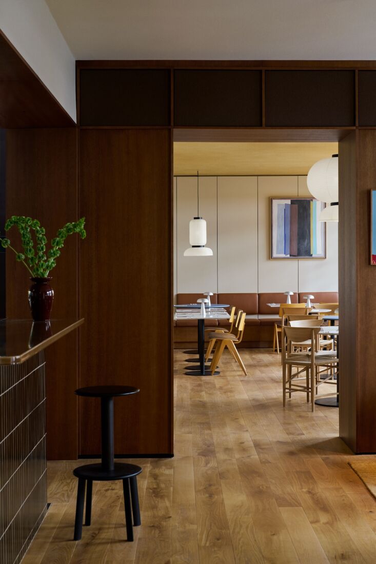 Hotel Petra lobby featuring stained oak veneer walls and a reception counter made of volcanic ash tiles.
