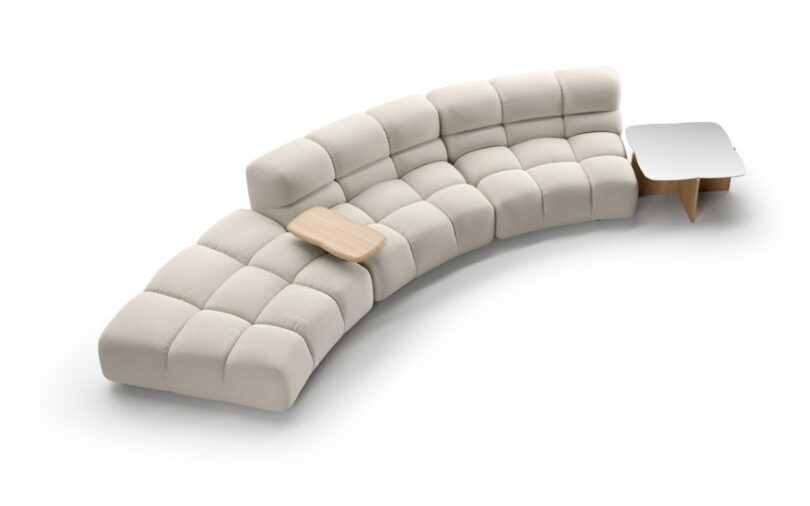 A beige modular sectional sofa with an integrated light wood side table and matching coffee table.
