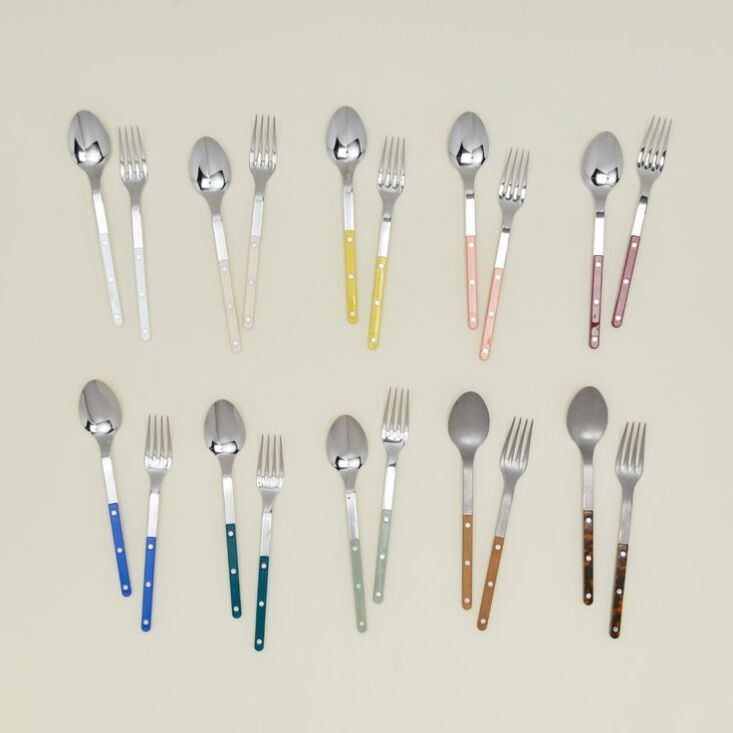A collection of colorful Sabre Paris flatware pieces in a retail setting.