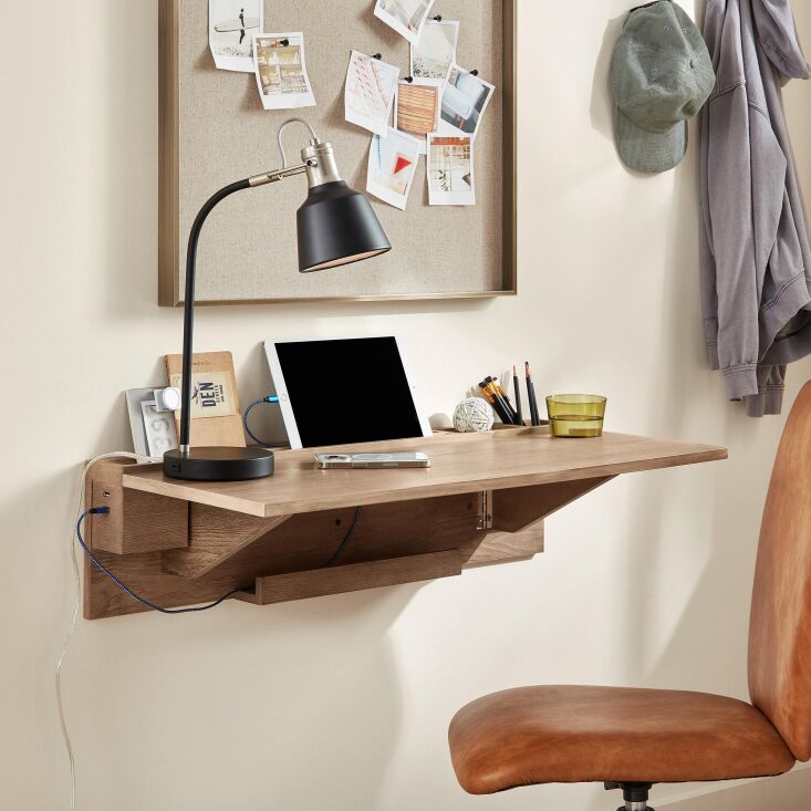 A white wall-mounted desk with built-in USB ports and a tablet ledge.