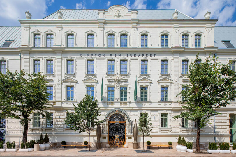 The exterior facade of the Kimpton BEM Budapest, a white neoclassical historic mansion.