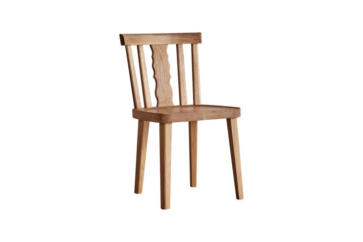 A solid oak dining chair with a decorative Swiss-style cutout in the backrest.
