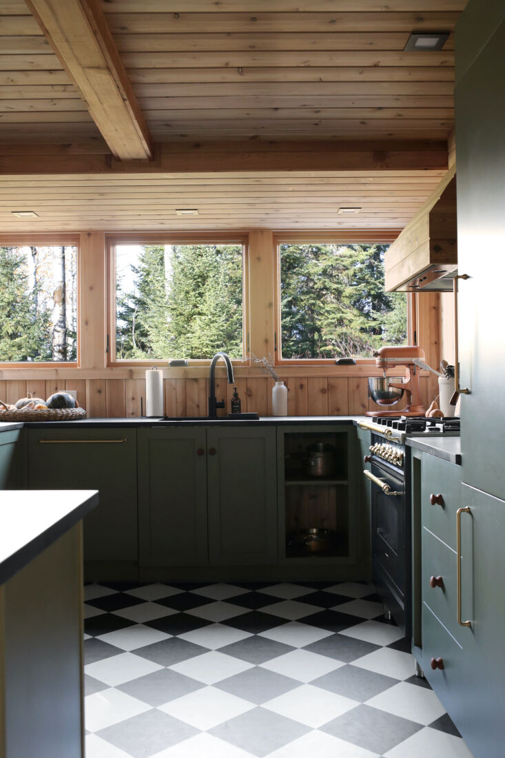 A black and cream checkered Marmoleum tile floor in a kitchen.