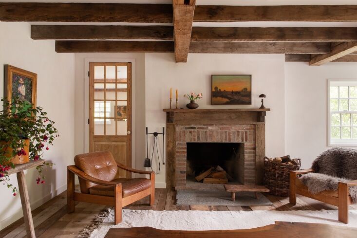 Living room interior showing exposed structural beams and a wooden mantelpiece handmade by Corbin Bernsen.
