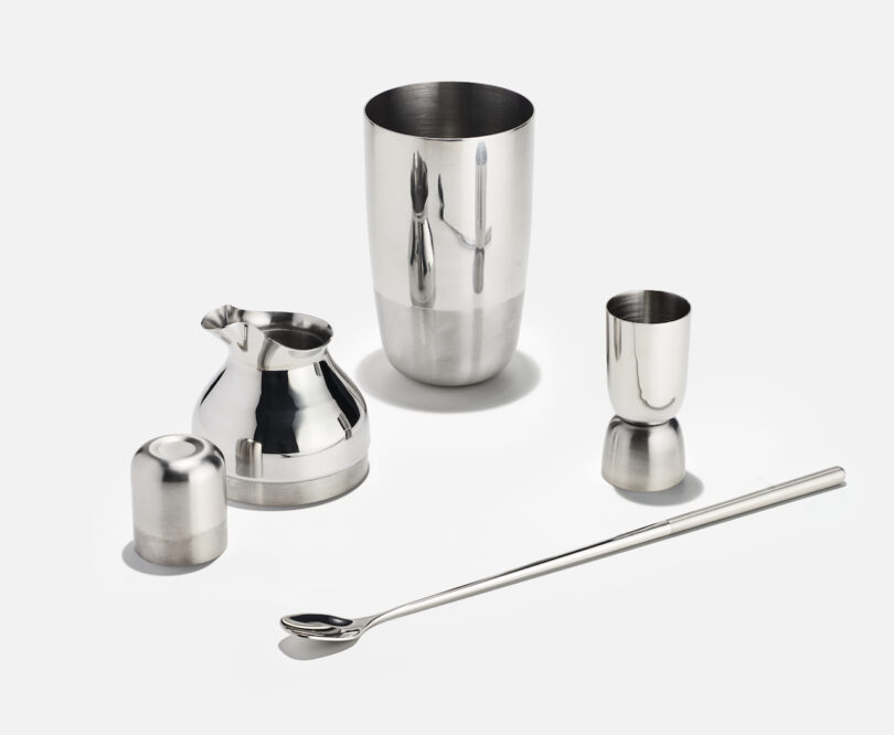 A clean studio shot of the stainless steel shaker, jigger, and mixing spoon on a white background.