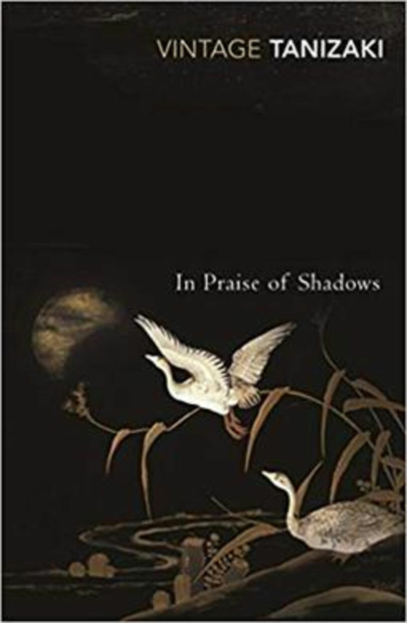 The cover of 'In Praise of Shadows' by Tanizaki with an amber cast of light across the scene.