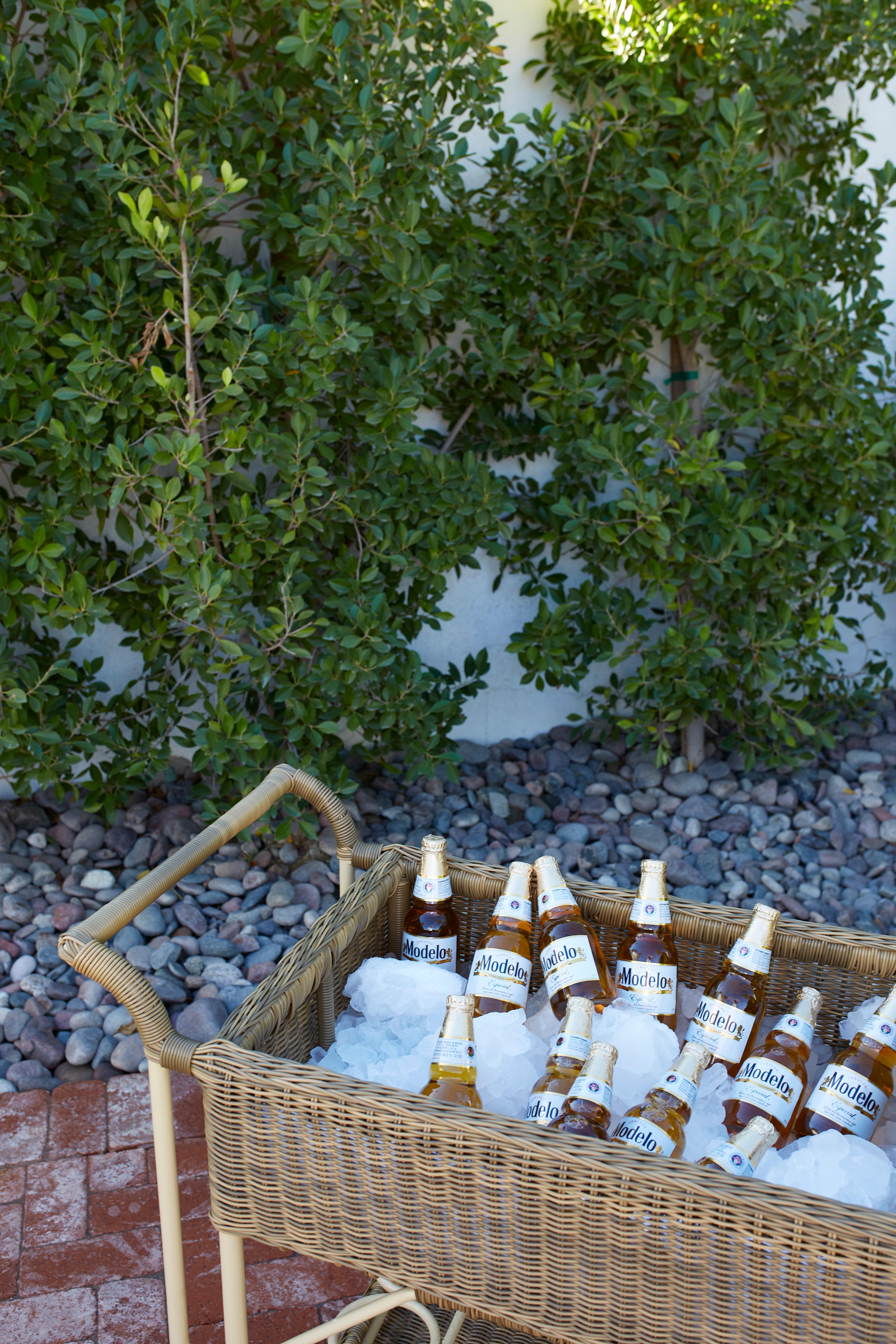 A refreshing basket of drinks placed in an outdoor leisure setting.