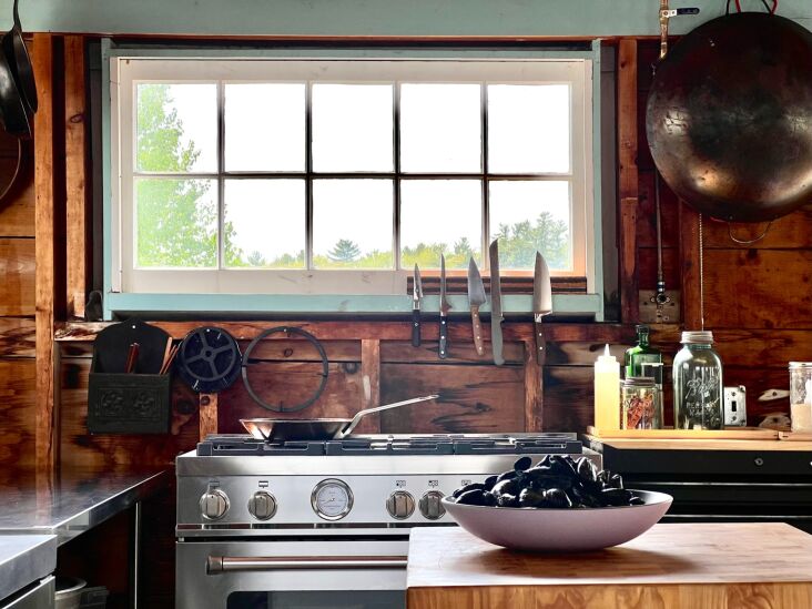 A professional Italian range paired with natural wood countertops and utilitarian storage.