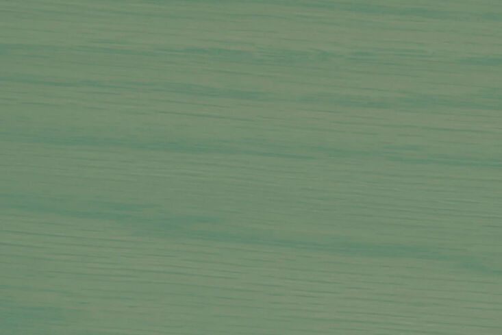 Close-up of wooden cabinet panels painted in a semi-transparent green stain.