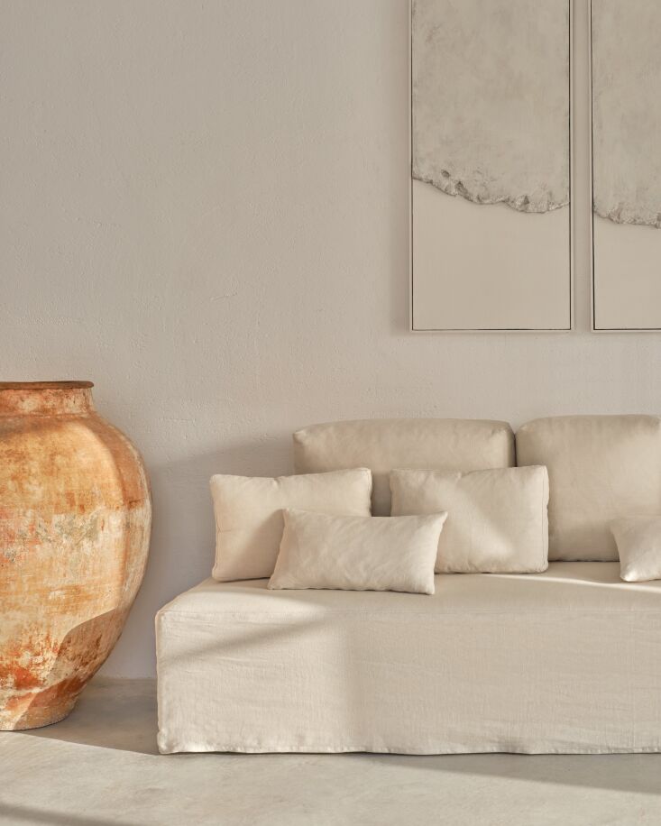 Detail of the 100% organic linen fabric cover being removed from a sofa cushion.