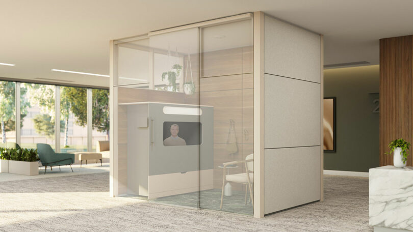 Interior view of an Ocular View privacy pod featuring a table, chair, and large monitor designed for focus.