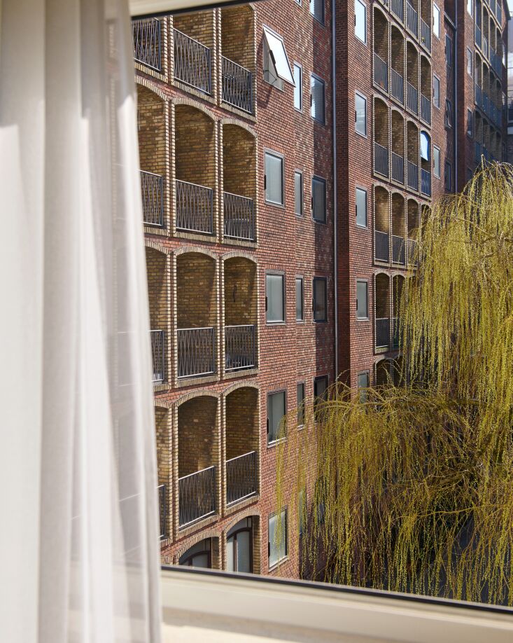 Close-up of the red and yellow machine-moulded brickwork and recessed balconies of the hotel facade.