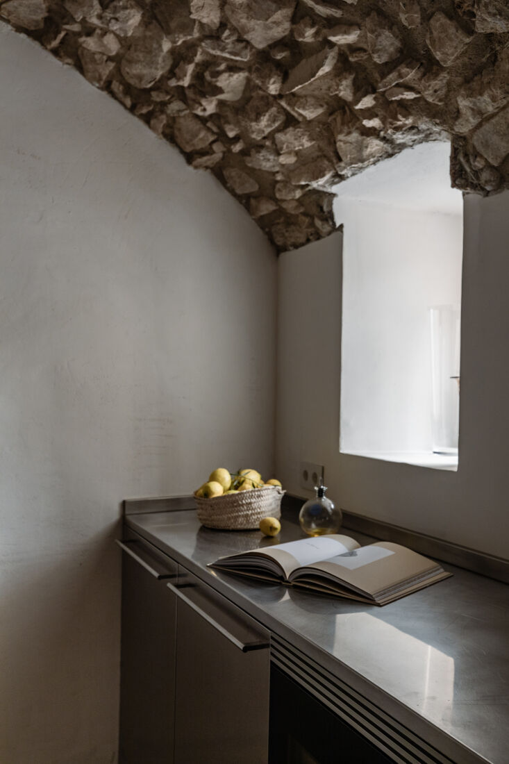 A low-angle shot of original stone ceiling arches in a restored kitchen area.