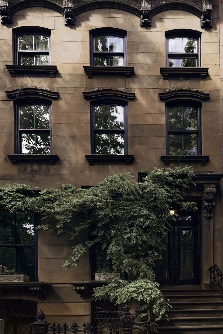 Rear facade of a brick brownstone with large Marvin windows and rebuilt masonry.